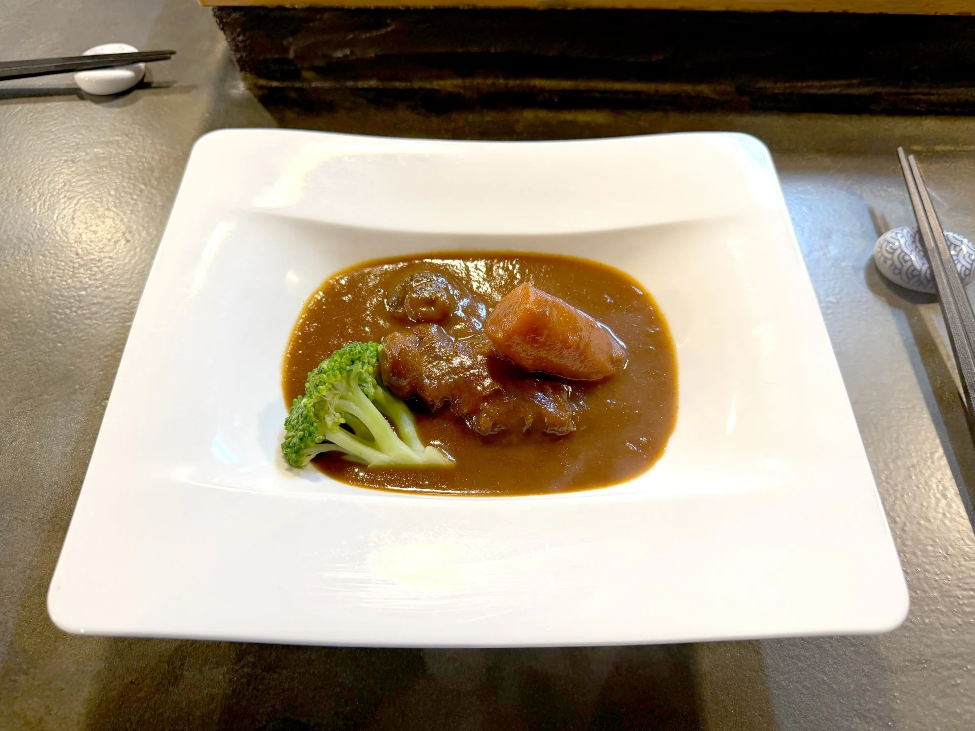 湯気の立つ和牛赤ワイン煮込みを器に盛り付けた料理の近景